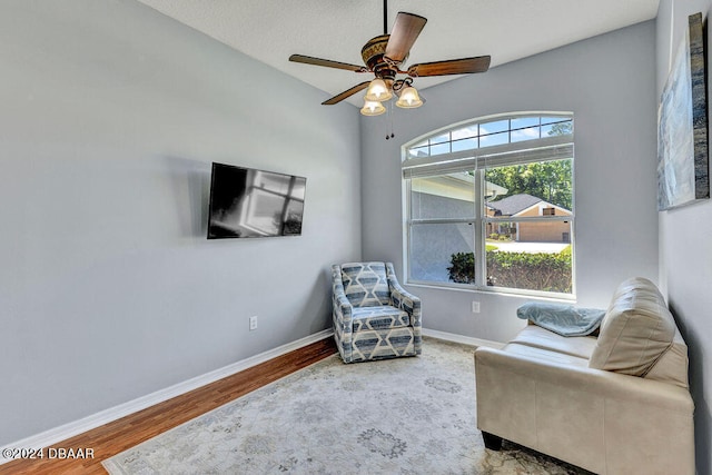 sitting room featuring ceiling fan, wood-type flooring, and lofted ceiling