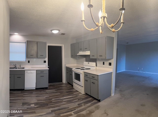 kitchen featuring sink, an inviting chandelier, decorative light fixtures, gray cabinets, and white appliances