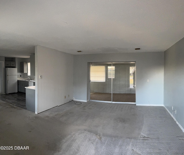 spare room with dark carpet and a textured ceiling