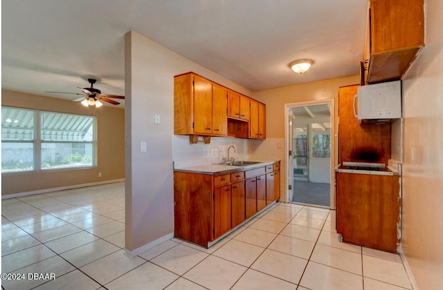 kitchen featuring light tile patterned flooring, ceiling fan, and sink