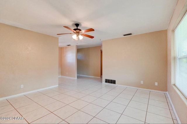 tiled spare room featuring ceiling fan