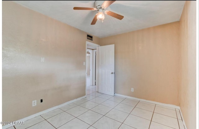 spare room featuring ceiling fan and light tile patterned floors