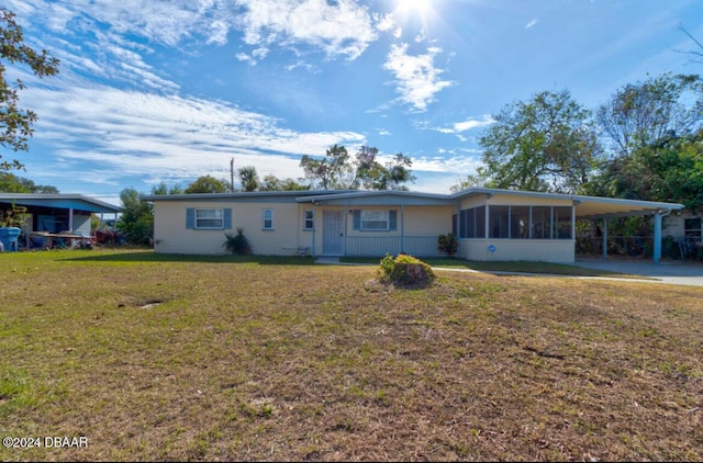 single story home with a carport, a sunroom, and a front yard