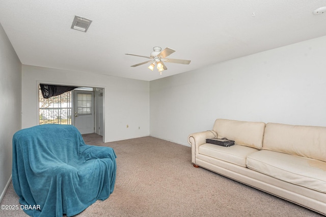 carpeted living room with ceiling fan