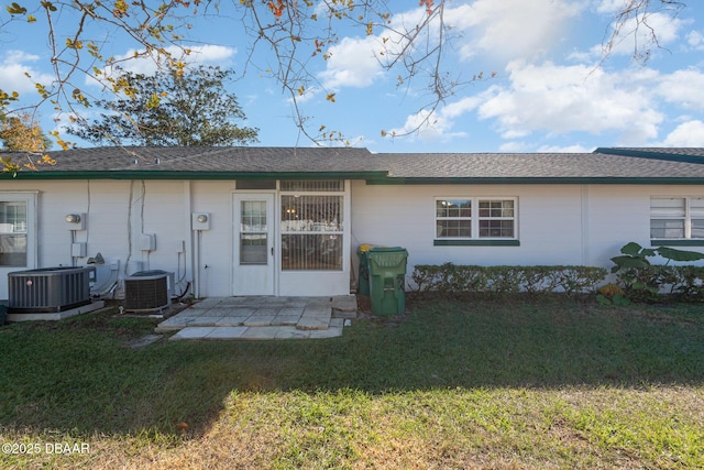 back of house featuring a lawn and central AC