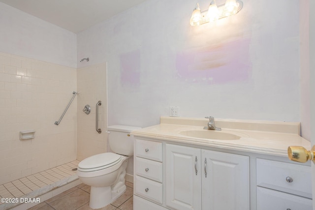 bathroom featuring tile patterned floors, vanity, toilet, and a tile shower