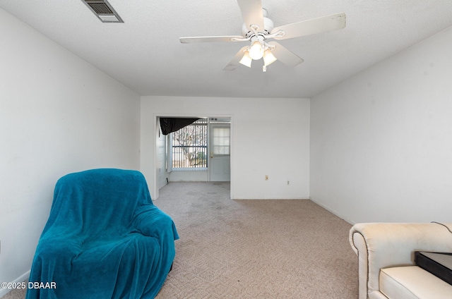 living area with light colored carpet and ceiling fan