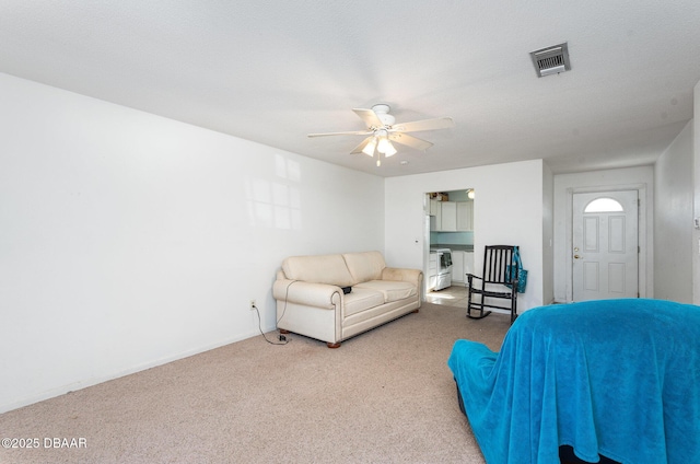 living room with ceiling fan, carpet floors, and a textured ceiling