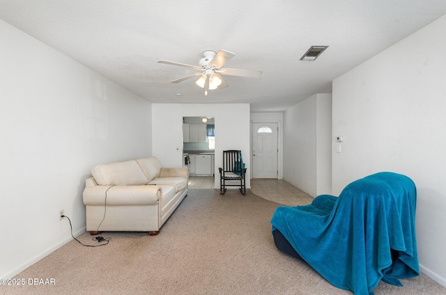 carpeted living room featuring a textured ceiling and ceiling fan