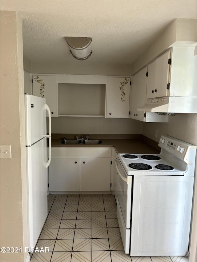 kitchen with white appliances, white cabinetry, sink, and a textured ceiling