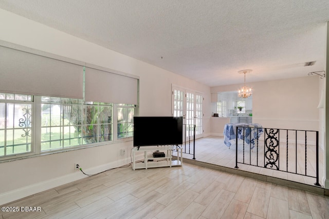 3630 Scott St, Port Orange, FL 32129 - living area with a chandelier, a textured ceiling, and light wood-type flooring