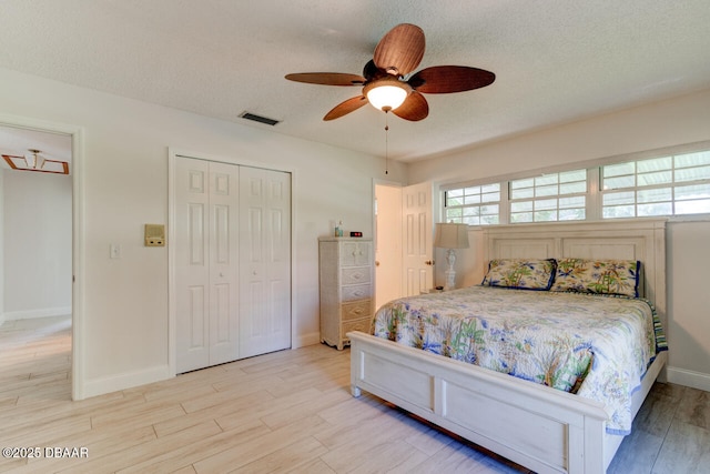 3630 Scott St, Port Orange, FL 32129 - bedroom with light wood-style floors, a closet, a textured ceiling, and a ceiling fan
