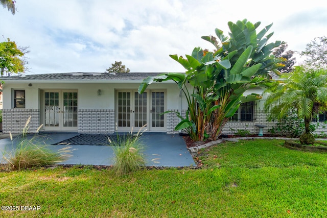 3630 Scott St, Port Orange, FL 32129 - back of property featuring french doors, a patio area, a lawn, stucco siding, and brick siding