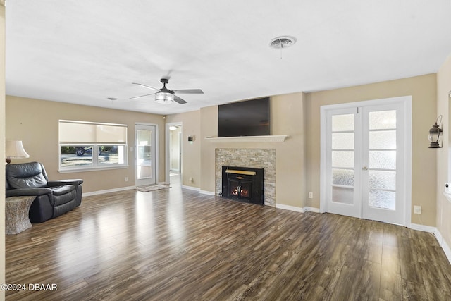 unfurnished living room with dark hardwood / wood-style floors, ceiling fan, a fireplace, and french doors