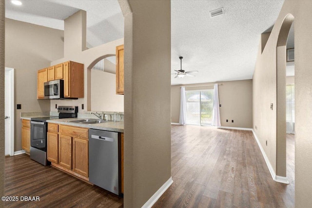 kitchen featuring visible vents, dark wood-type flooring, a ceiling fan, a sink, and appliances with stainless steel finishes