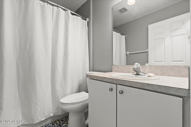 full bathroom featuring vanity, toilet, visible vents, and a textured ceiling