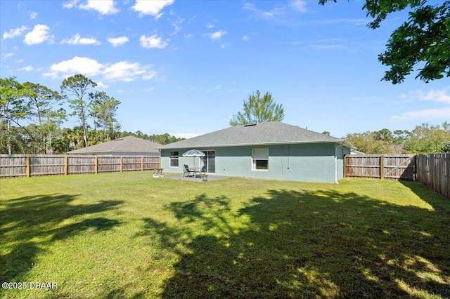 rear view of property featuring a patio area, a yard, a fenced backyard, and stucco siding