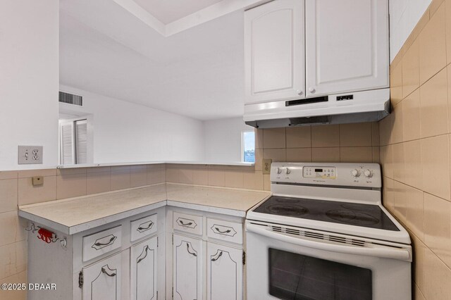 3009 N Halifax Ave Unit 9, Daytona Beach, FL 32118 - kitchen with white electric range oven, white cabinetry, a peninsula, under cabinet range hood, and visible vents