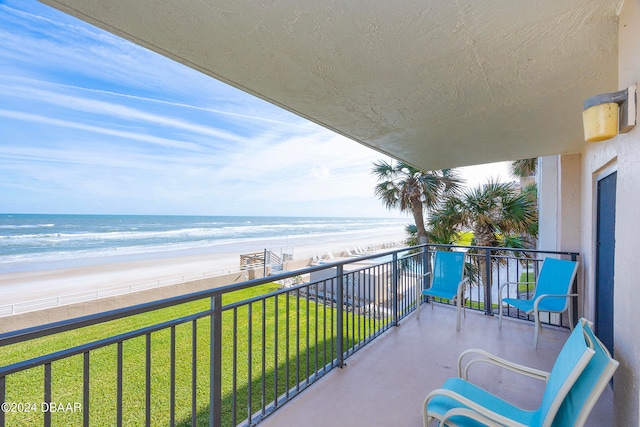 balcony with a water view and a view of the beach