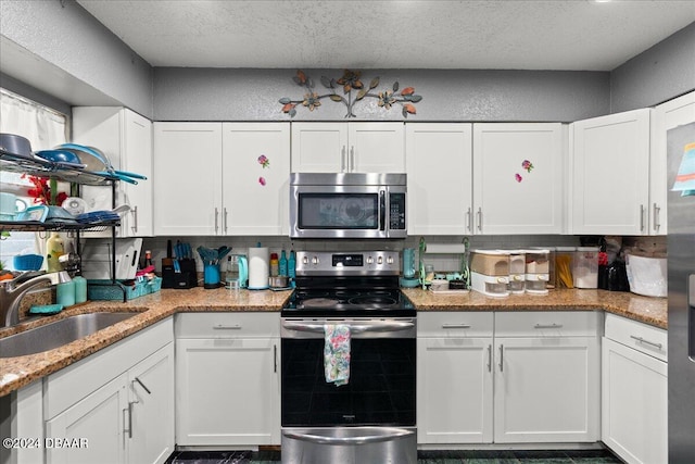 kitchen featuring stainless steel appliances, white cabinets, sink, and backsplash