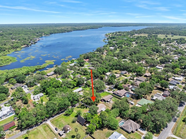 drone / aerial view with a water view, a view of trees, and a residential view