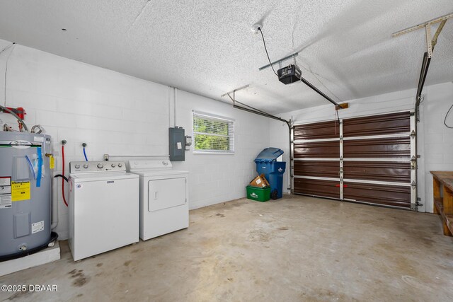 garage featuring washing machine and clothes dryer, concrete block wall, a garage door opener, water heater, and electric panel