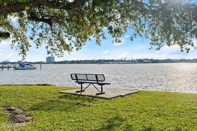 view of dock featuring a lawn and a water view