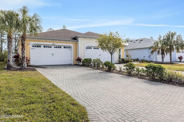 single story home with a garage and a front lawn