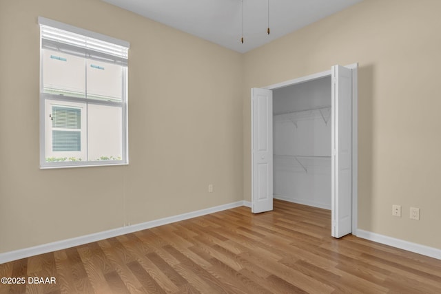 unfurnished bedroom with a closet and light wood-type flooring