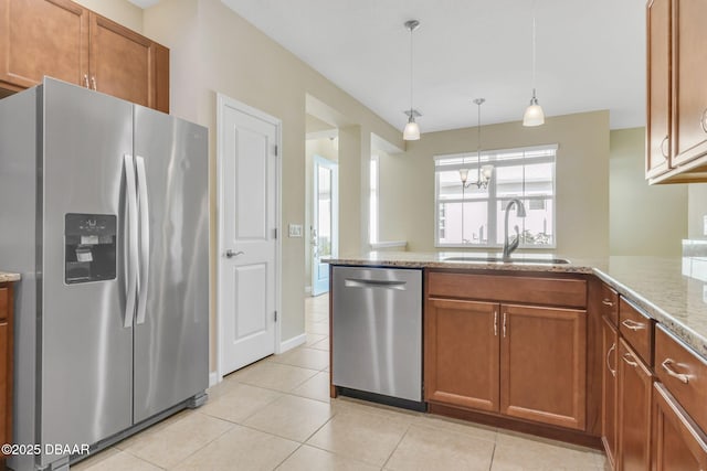 kitchen with pendant lighting, sink, light tile patterned floors, and appliances with stainless steel finishes