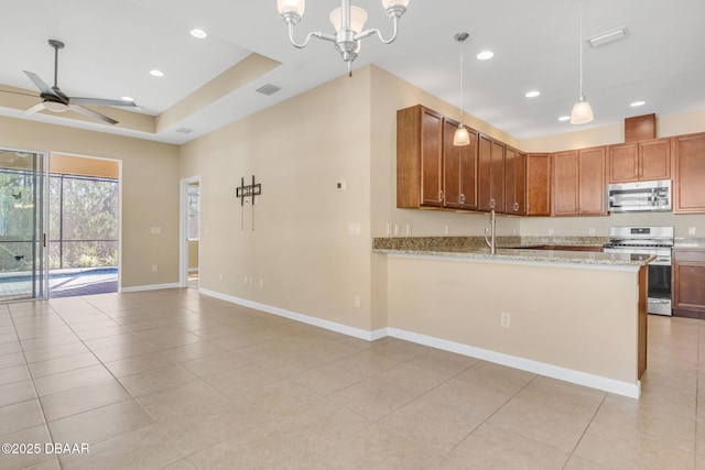 kitchen with hanging light fixtures, light stone countertops, appliances with stainless steel finishes, and kitchen peninsula