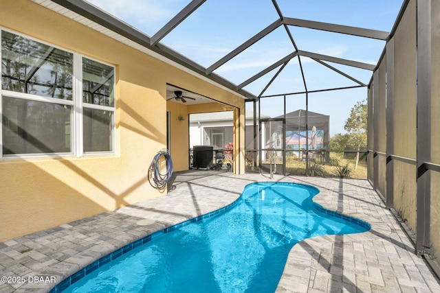 view of swimming pool with ceiling fan, a lanai, and a patio