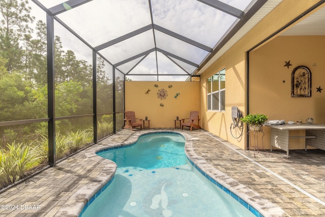 view of swimming pool featuring a lanai and a patio area