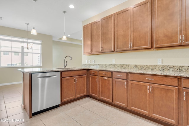 kitchen featuring pendant lighting, sink, stainless steel dishwasher, light tile patterned floors, and light stone countertops