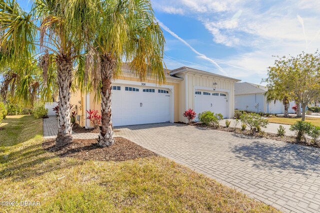 ranch-style home featuring a garage and a front lawn