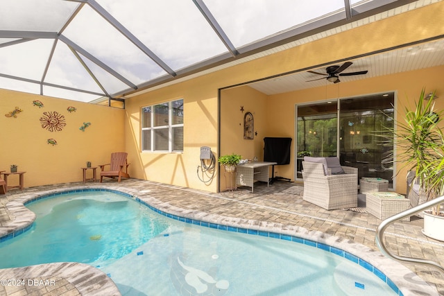 view of swimming pool featuring ceiling fan, an outdoor hangout area, glass enclosure, and a patio