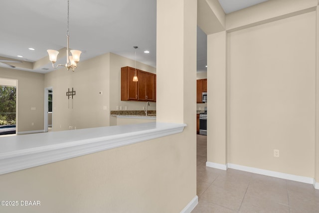 kitchen featuring sink, light tile patterned floors, an inviting chandelier, stainless steel appliances, and decorative light fixtures