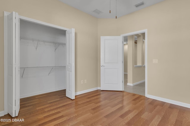 unfurnished bedroom with light hardwood / wood-style floors and a closet