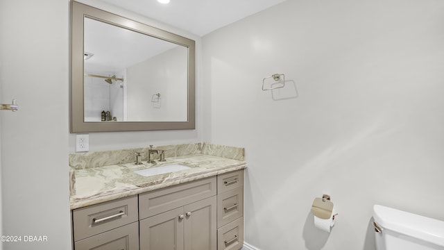 bathroom featuring a shower, vanity, and toilet