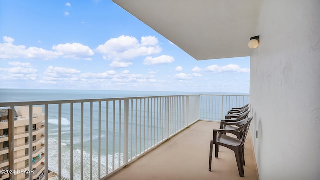 balcony featuring a water view and a beach view