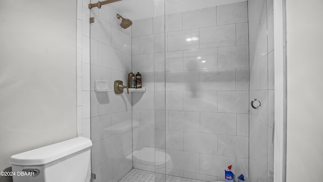 bathroom with a tile shower and toilet