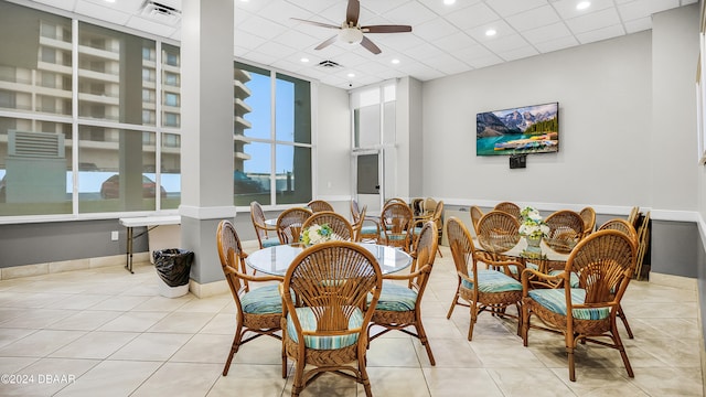 dining space with a paneled ceiling, ceiling fan, and light tile patterned floors