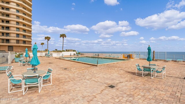 view of pool featuring a patio area and a water view