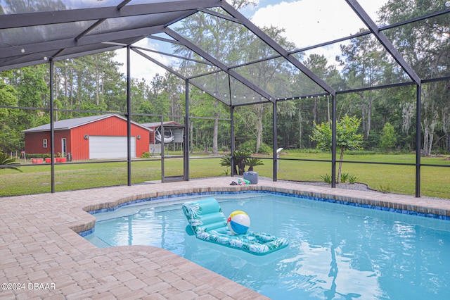 view of pool featuring an outbuilding, glass enclosure, a garage, and a lawn