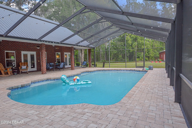 view of pool featuring a patio, a yard, glass enclosure, and french doors