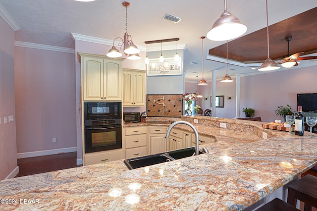 kitchen with sink, black appliances, light stone countertops, a breakfast bar area, and pendant lighting