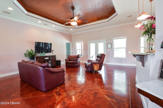 living room featuring crown molding, ceiling fan, and a raised ceiling