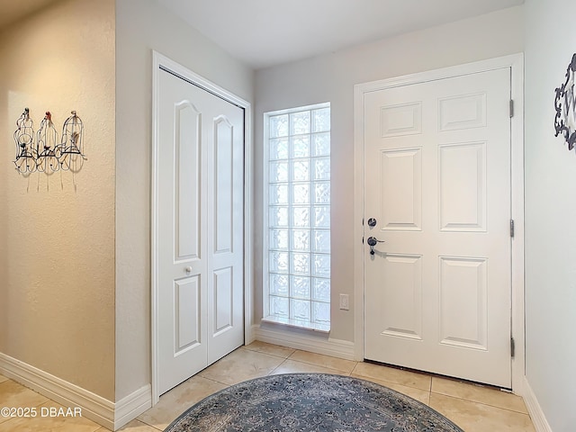 entrance foyer featuring baseboards and light tile patterned floors