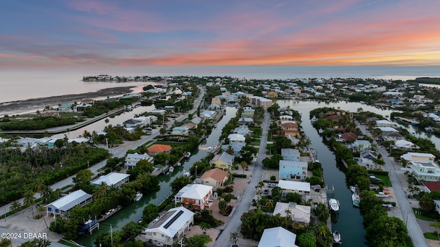 aerial view at dusk featuring a water view