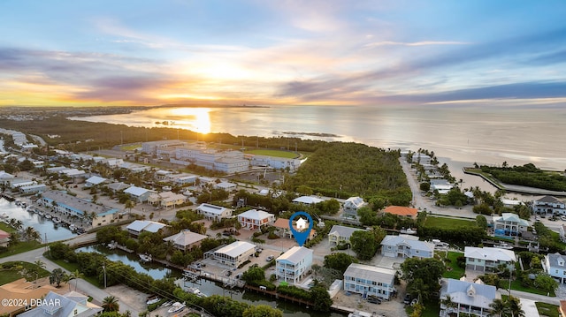 aerial view at dusk featuring a water view